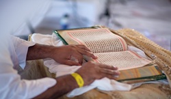 Man reading the holy Granth Sahib at traditional Indian wedding